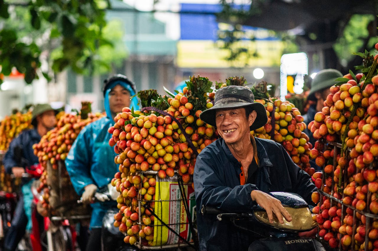 Joyful farmers with lychee harvest in Bac Giang, Vietnam, highlighting culture and agriculture.